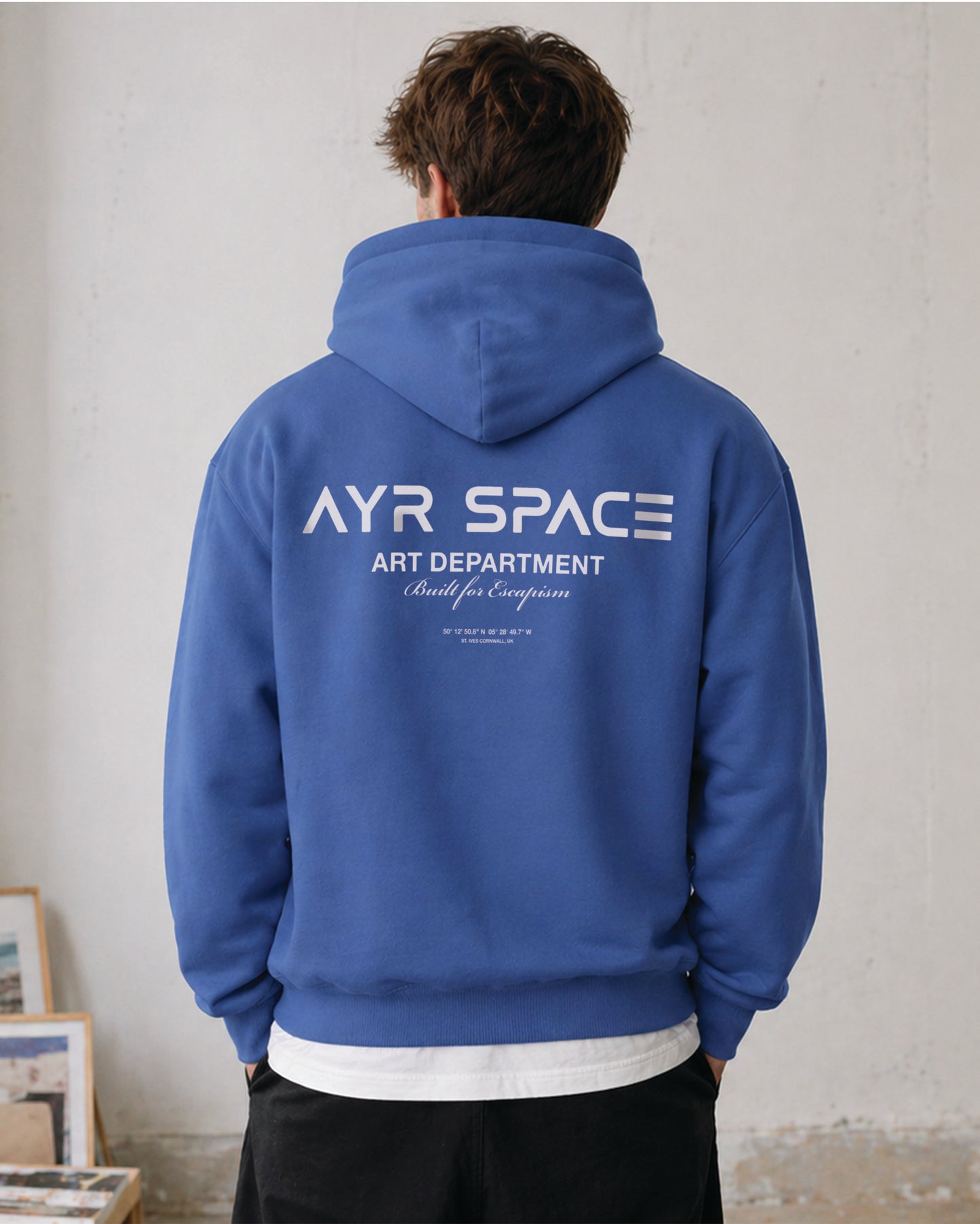 Person wearing a blue hoodie with 'AYR SPACE' branding on the back.