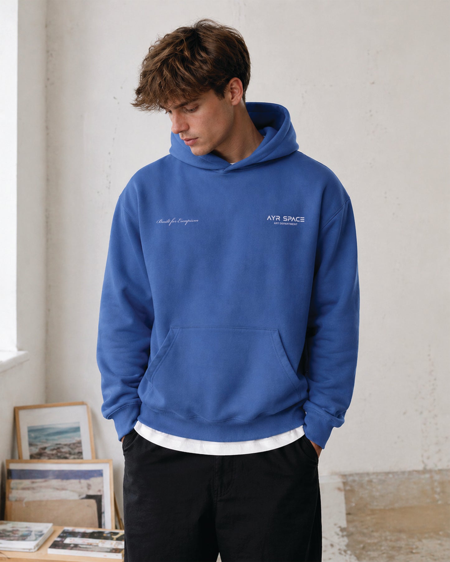 Person wearing a blue hoodie with front graphic print detailing.