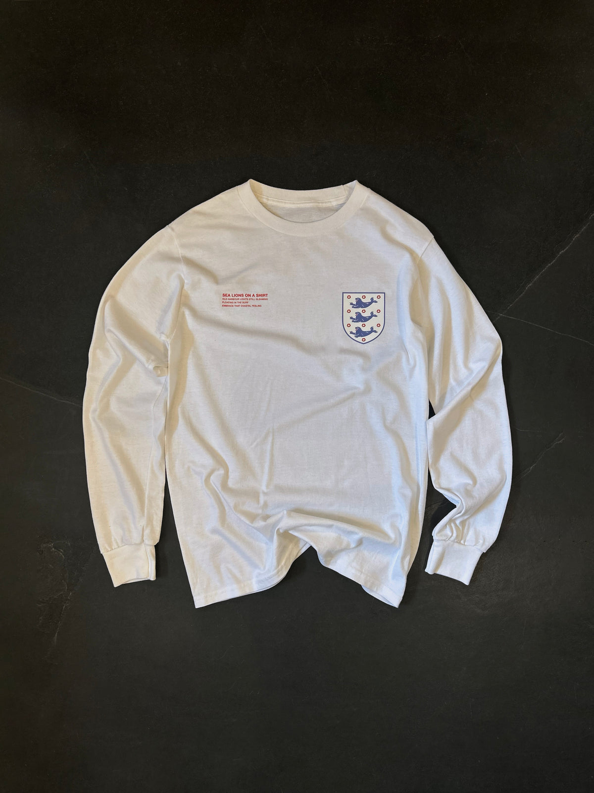 Front of the Sea Lions Long Sleeve in Home White, laid flat: retro-style crest with three sea lions on the chest and a small red text print opposite